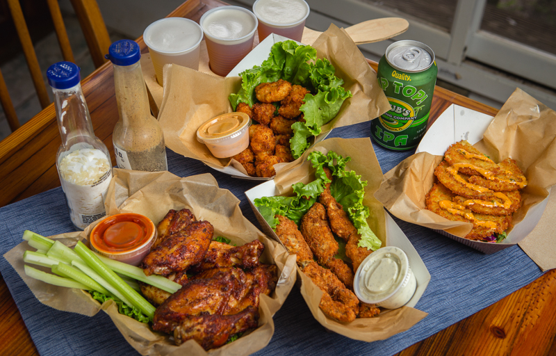 Smoked-fried frogs legs, with fried green tomotoes, fried gator bites, and smoked chicken wings. Photo by Wyatt Kostygan