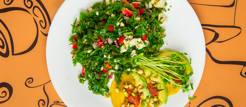 Cafe Evergreen's raw golden beet stuffed with cashew cheese topped with pomodoro avacado and sprouted mung beans paired with  raw kale tabouli.