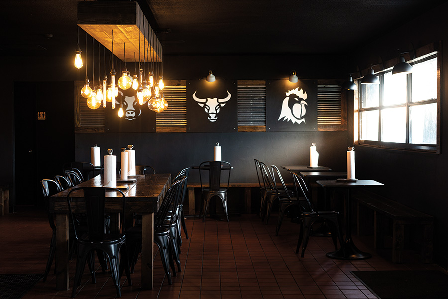 Jet black  interior walls paired with  gleaming black lacquered chairs set a sophisticated edge to this BBQ joint.Photography by Wyatt Kostygan