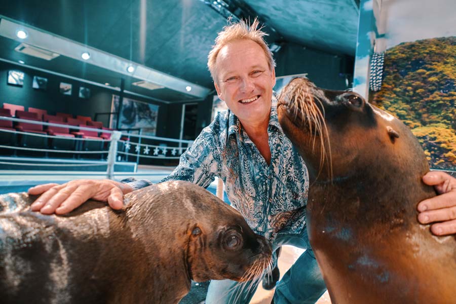Marco Peters poses with a couple of flippered friends,  Stella and Kitty, at the Sarasota Sea Lion Preserve. Photo by Wyatt Kostygan.