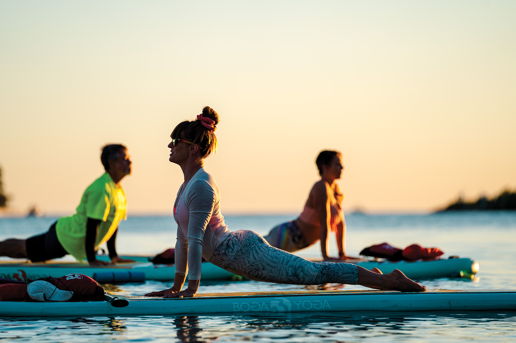 Ouellete leads a sun salutation at sunset off the shores of Longboat Key on BOGA paddleboards.