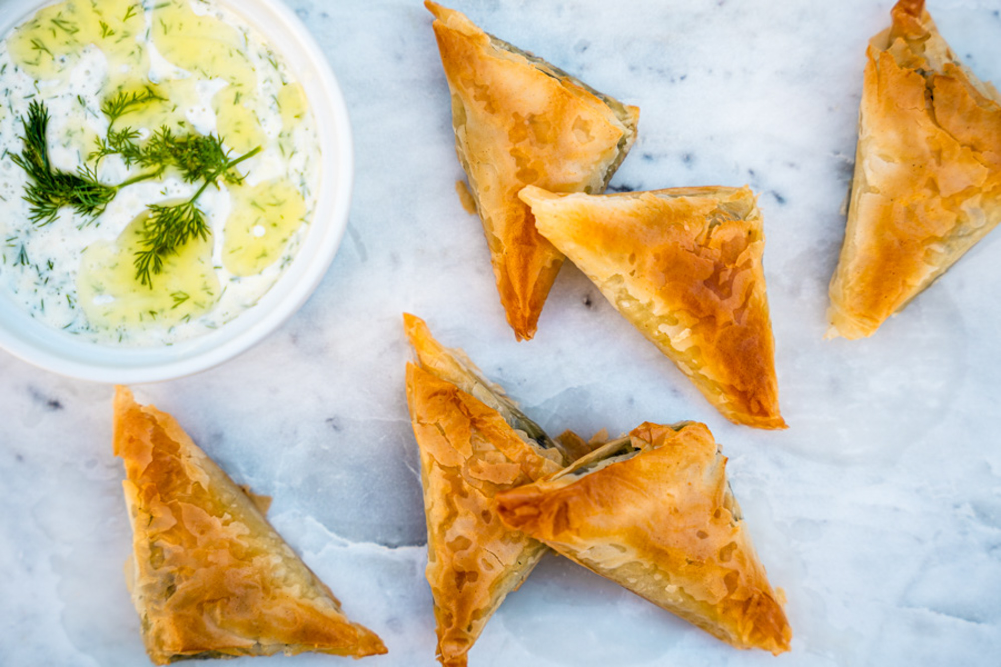 Spanakopita comes with a tzatziki sauce loaded with dill flavors.